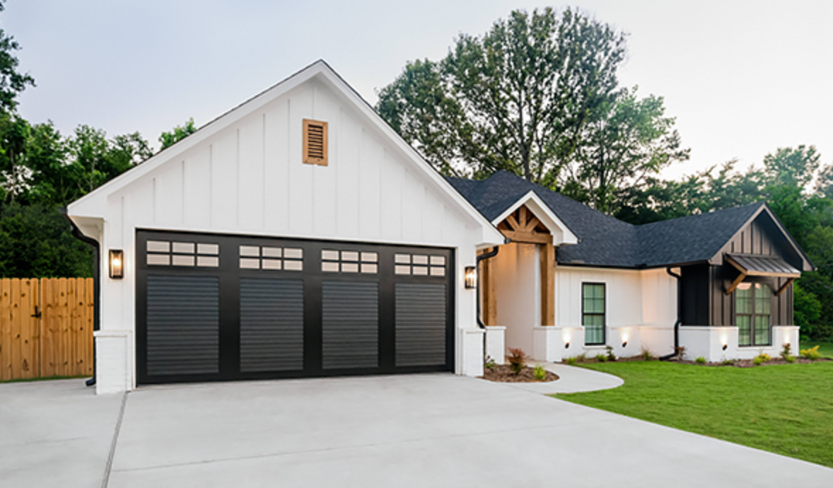 Black and white image of a closed industrial garage door with corrugated metal exterior.